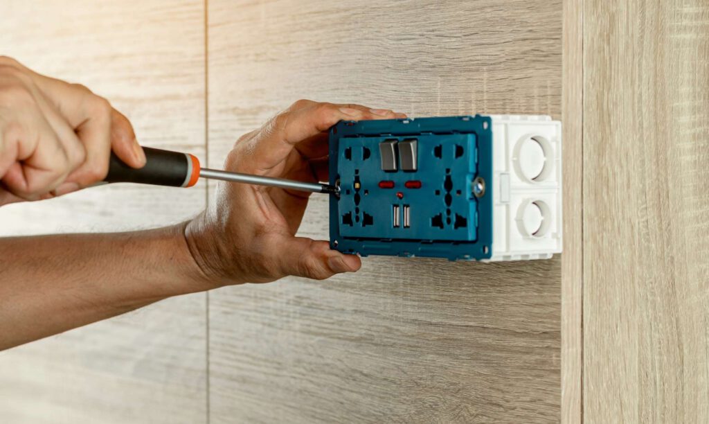 okc handyman working on an outlet